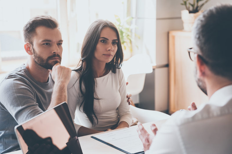 financial advisor talking with a young couple